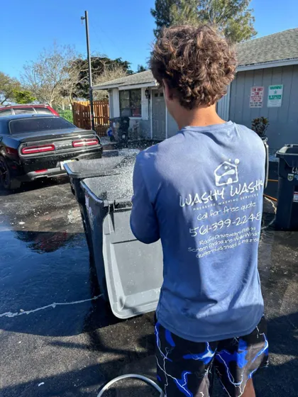 A WashyWashy crew member in a branded shirt starting a job