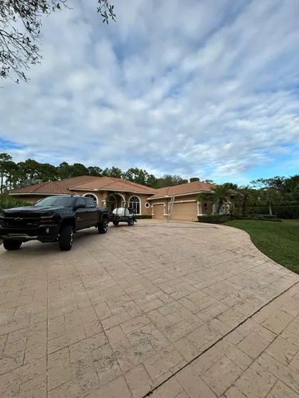A long stamped-concrete estate driveway freshly pressure washed