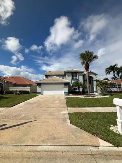 Bright driveway leading to a two-story home