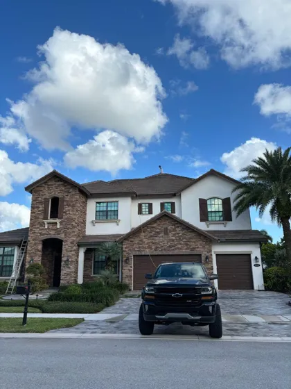 A two-story stone and stucco home after an exterior wash