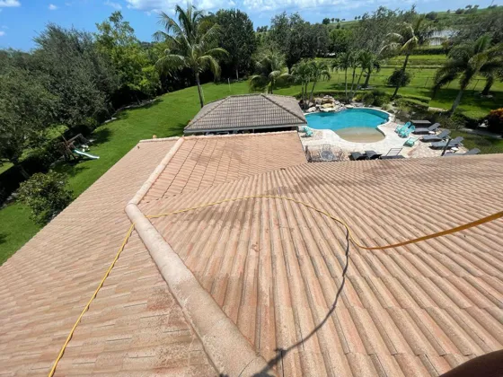 Tile roof mid-wash with a pool below